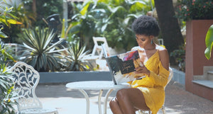 Beautiful Nigerian girl sitting in the garden in Lagos reading a book, enjoying the nature and cool breeze.